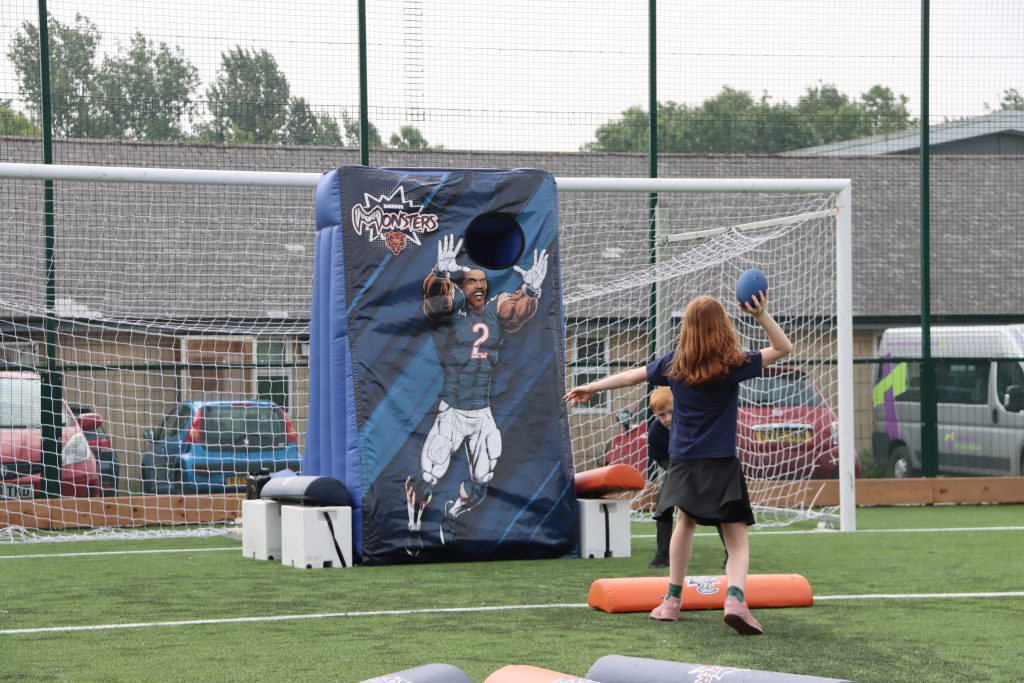 A girl throwing a football at a target